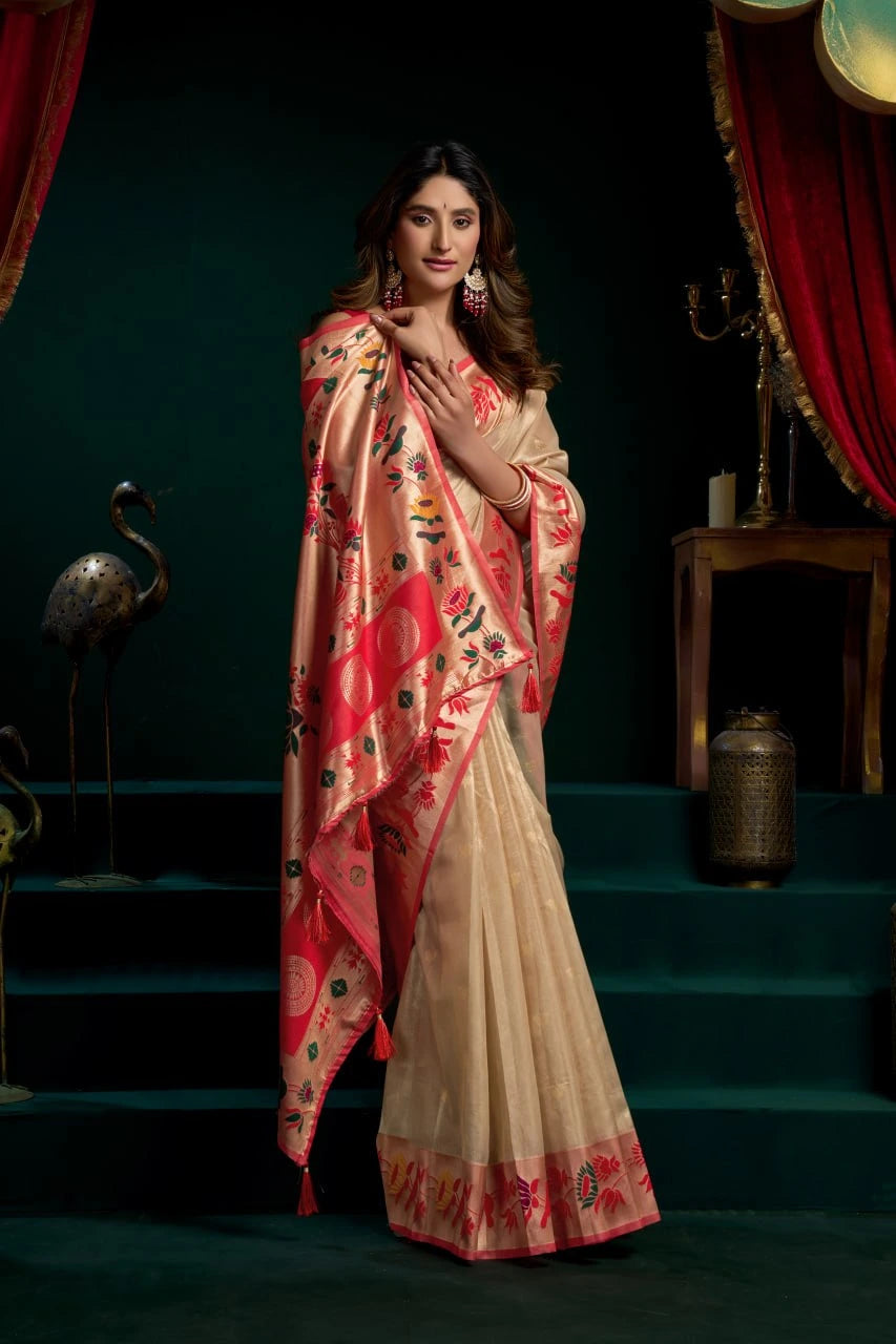Woman wearing a saree with a red and beige pattern on a dark background